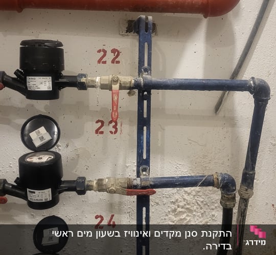 מד מים עם צינורות וברזים אדומים